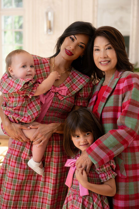 Two woman and 2 children posing for a photo in the interior of a home. 