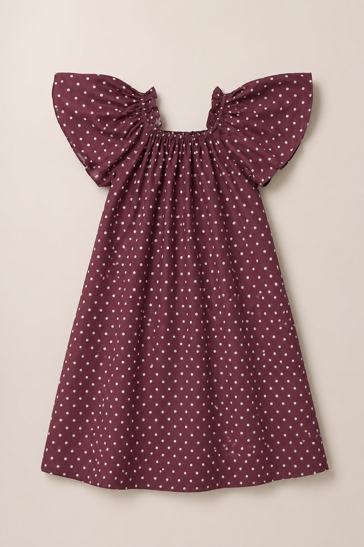 The Ivy City Co Teen Blakely Dress in Aubergine Ditsy Dot—a maroon viscose midi dress with white polka dots, short flutter sleeves, and a gathered neckline—is displayed against a plain light background.
