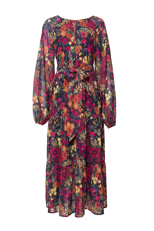 The Imogen Dress in Night Garden by Ivy City Co is a long-sleeved, sheer maxi dress with a tie waist and a vibrant floral print in red, yellow, orange, and blue hues. Featuring a flowy skirt and gathered cuffs, this fall-inspired dress is both maternity friendly and effortlessly elegant.