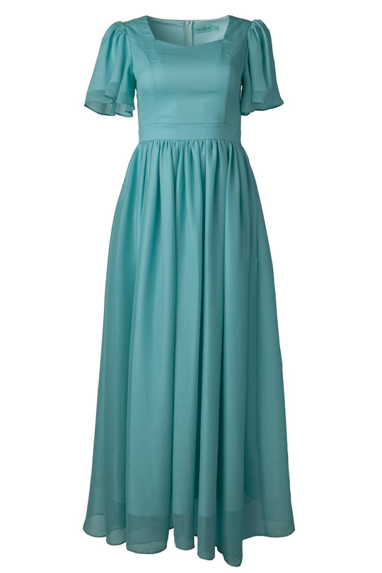 The Abbie Dress in Seaglass Chiffon by Ivy City Co is a long, light blue dress featuring short puffed sleeves, a fitted bodice, and a flowing gathered skirt. With its square neckline and airy Seaglass Chiffon fabric, this elegant design is ideal for bridesmaids or formal and semi-formal occasions.