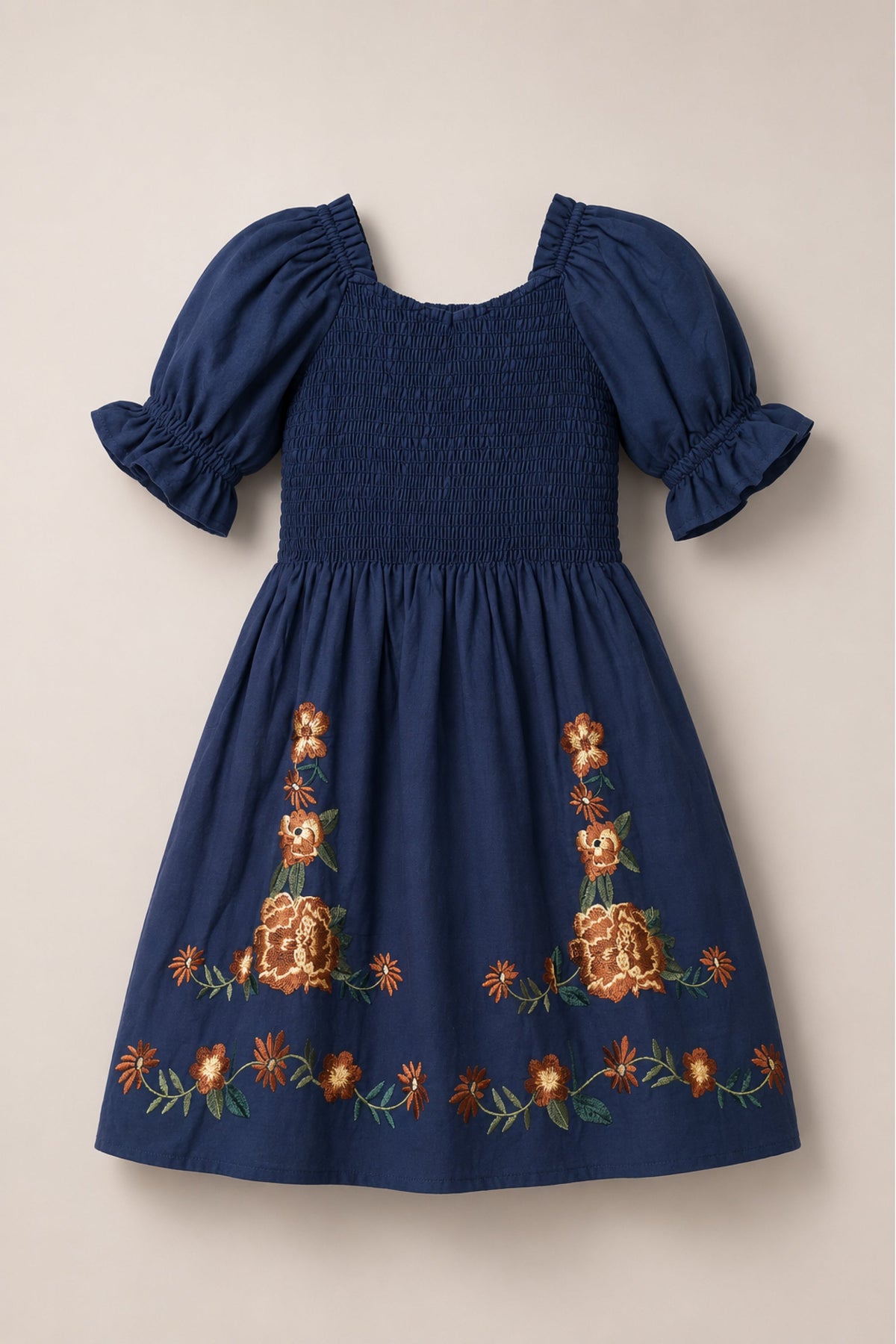 The Mini Teagan Dress in Navy Embroidered Fall Floral by Ivy City Co features balloon sleeves, a smocked bodice with ruffled cuffs, and orange and yellow floral embroidery accenting the skirt and hem.
