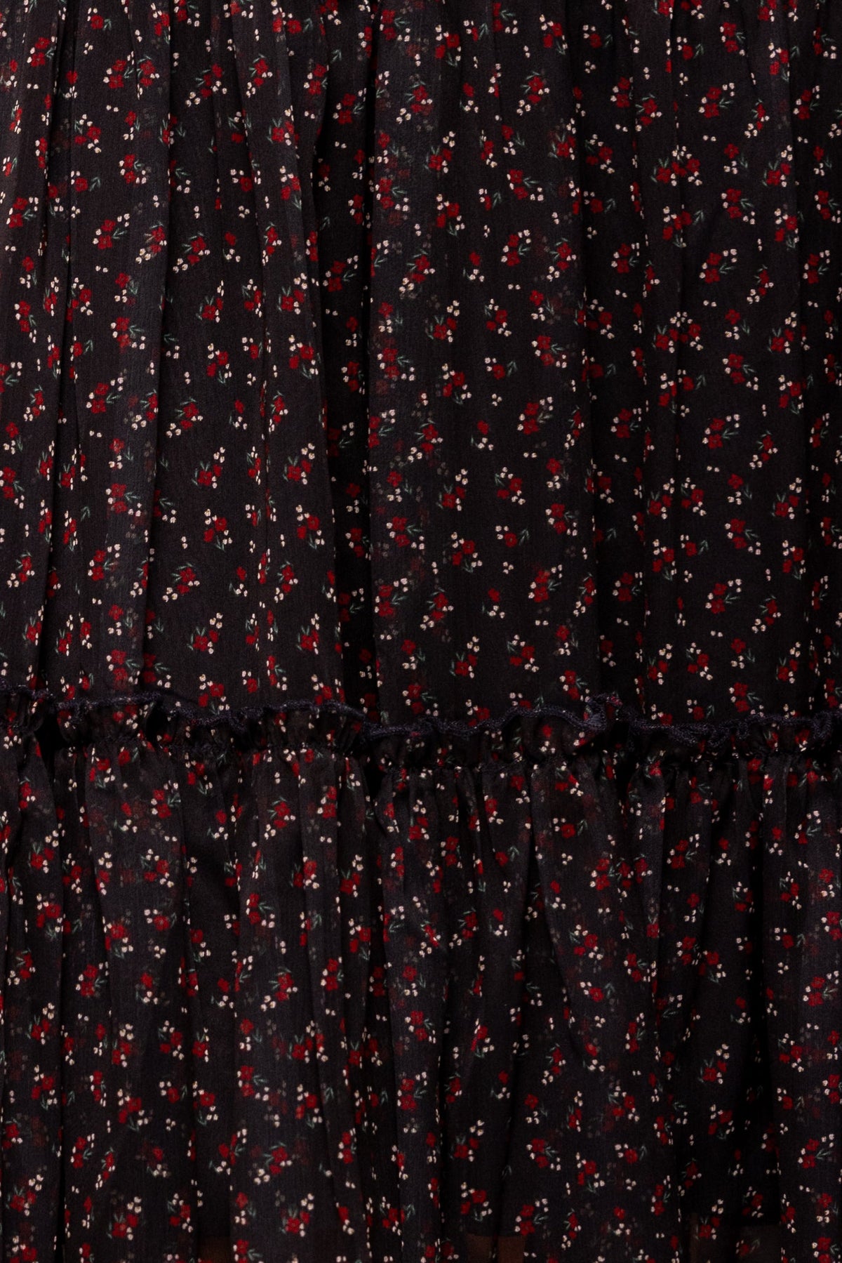 Close-up of the Ivy City Co Madeline Dress in Black Ditsy Floral, showcasing its ruffled seam and delicate white and red ditsy floral print—designed to be both nursing friendly and maternity friendly for comfortable, stylish wear.