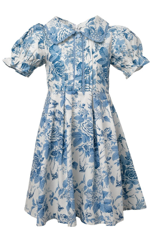 The Mini Sophia Dress in Blue Floral by Ivy City Co features short puff sleeves, a wide ruffled collar with bow, and a fitted waist—making it the perfect girls' spring dress for any occasion.